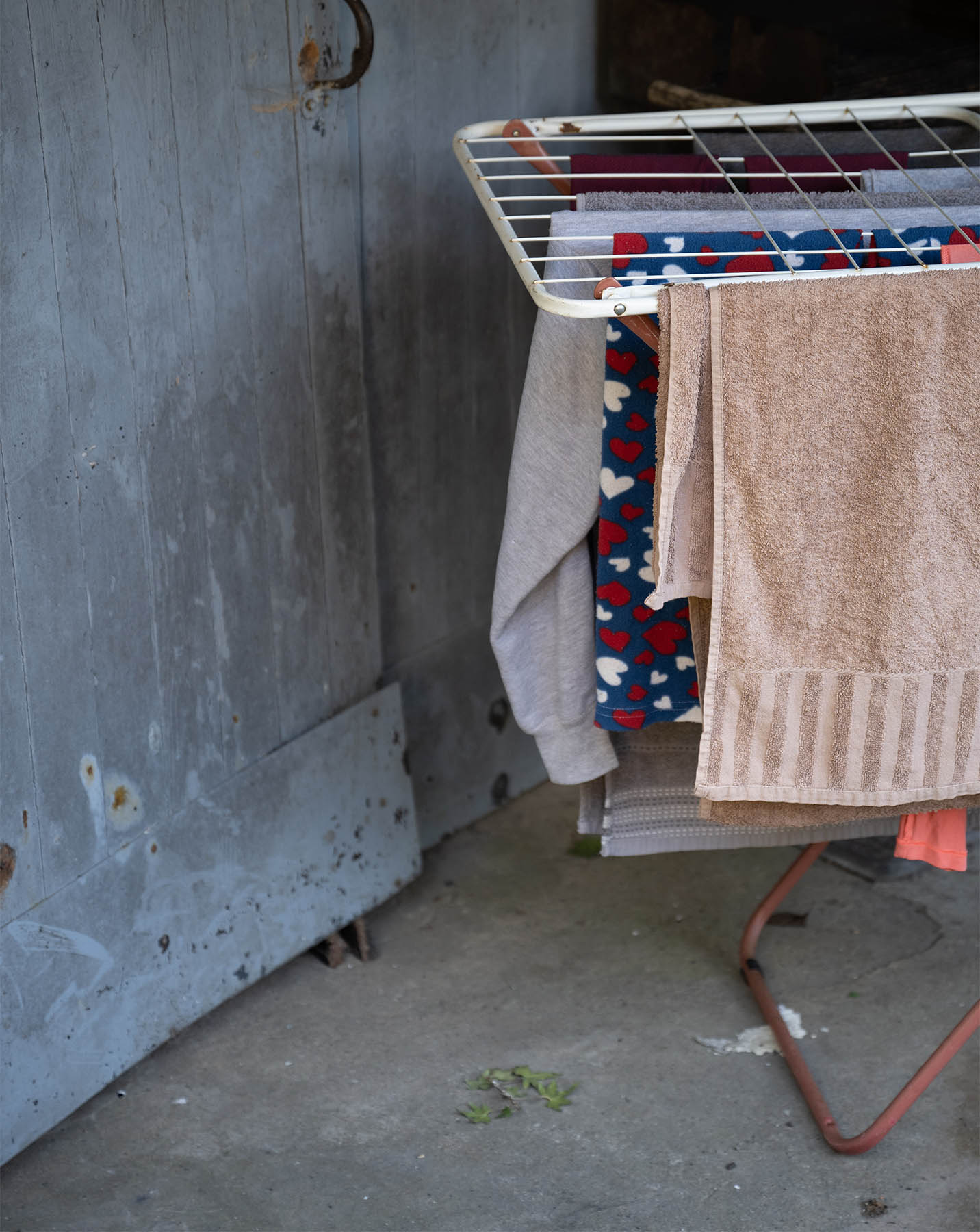 Auf einem Wäscheständer sind Handtücher aufgehängt. Eines davon mit einem Herzmuster