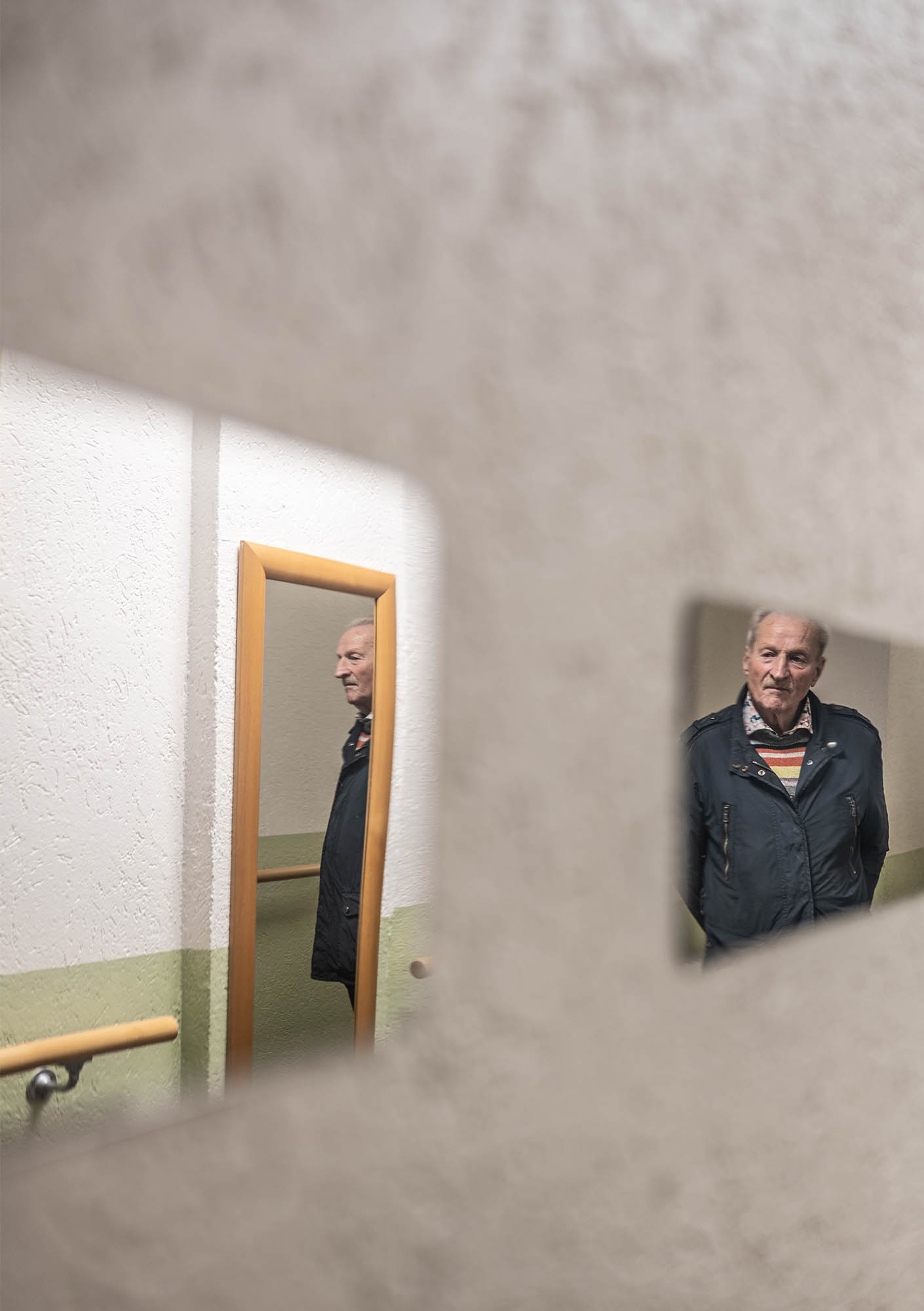 Blick auf zwei Spiegel in denen sich durch einen dritten auf der gegenüberliegenden Wand zwei verschiedene Perspektiven auf die Katze entstehen