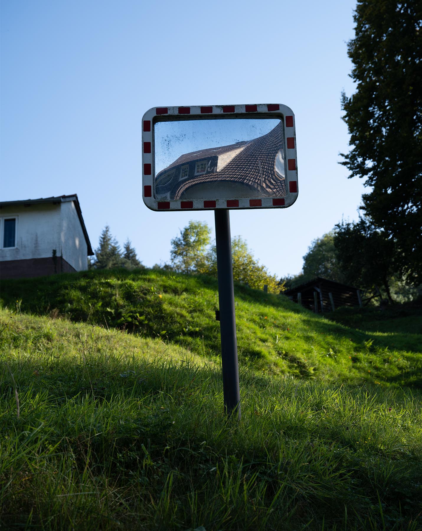 Ein Verkehrspiegel bietet einen verzerrten Blick auf ein Hausdach